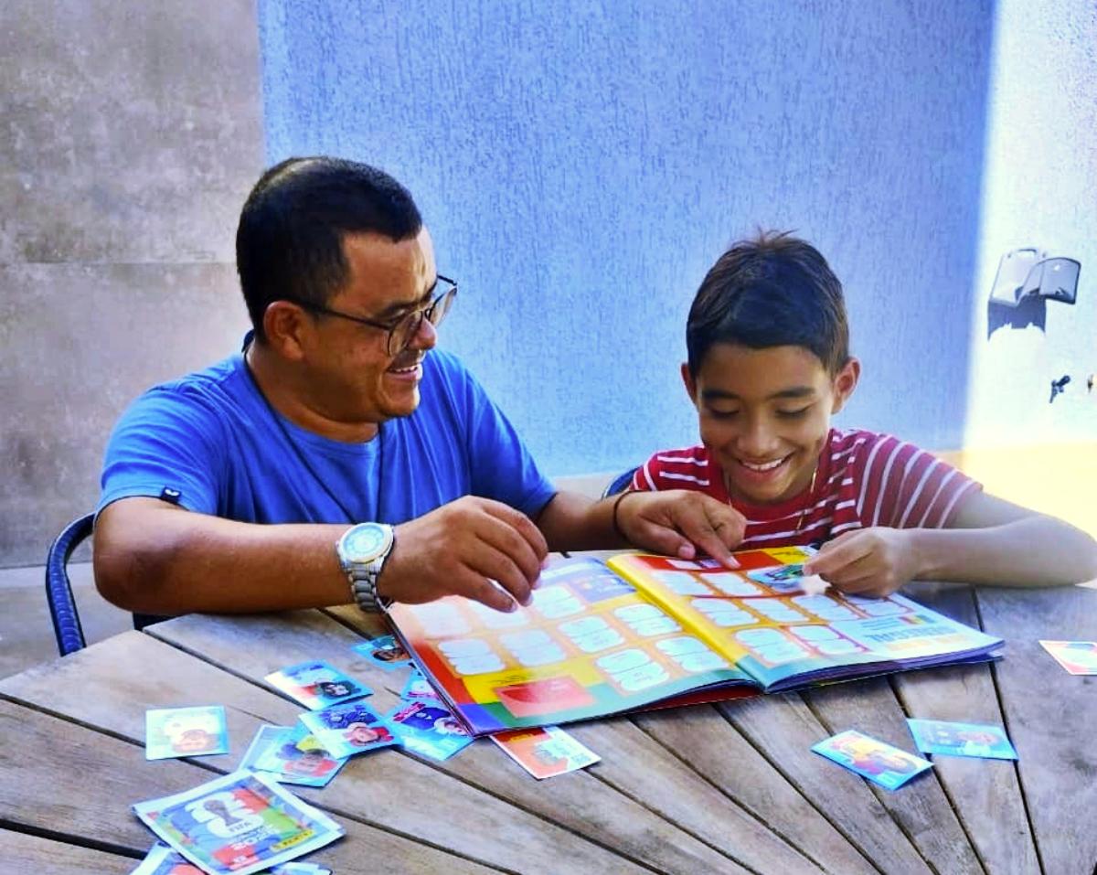 José Orlean e seu filho Heitor colando figurinhas